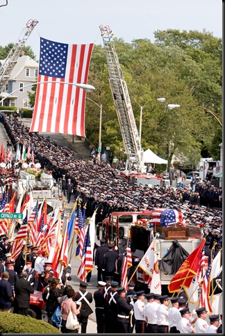 Thousands of firefighters from around the country line the street as fire engine bearing the casket of Paul Cahill is carried away from Holy Name Church in West Roxbury, Mass. Cardinal Sean P. O’Malley presided at the Sept. 6 funeral Mass for the fallen Boston firefighter. Pilot photo/ Gregory L. Tracy  